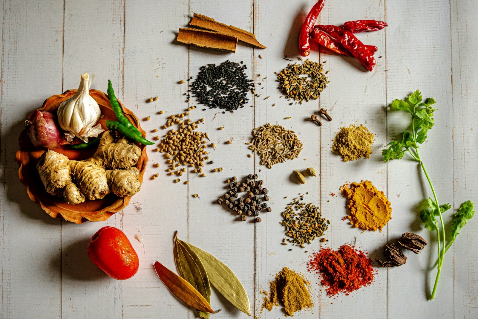 An array of Indian spices and seeds laid out on wood — the breadth of global agro trade